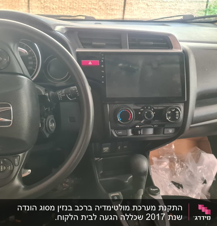 פנים רכב עם הגה, מסך מגע ולוח בקרה